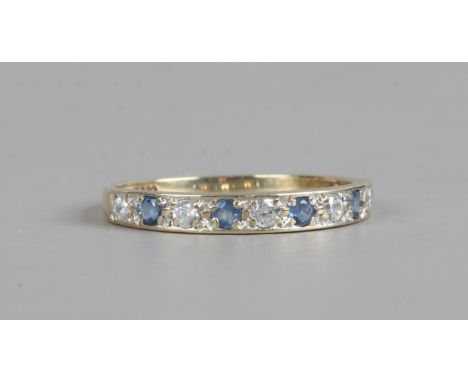 A 9ct gold half eternity ring set with sapphires and white paste stones, size M1/2.