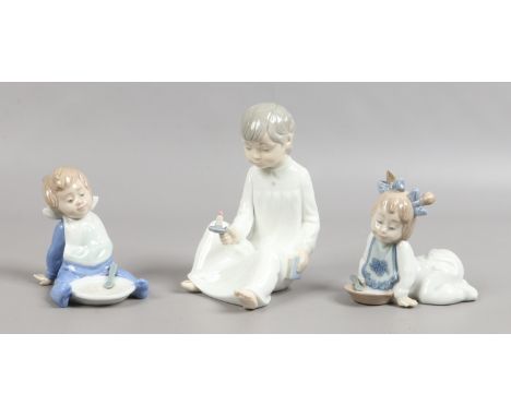 Three Nao figures modelled as children including a pair each with a supper dish.