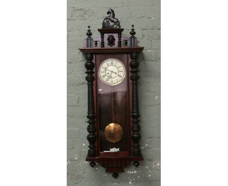 A Victorian Gustav Becker Silesia wall clock with enamel dial Roman numerals and chiming on a gong complete with key and pend