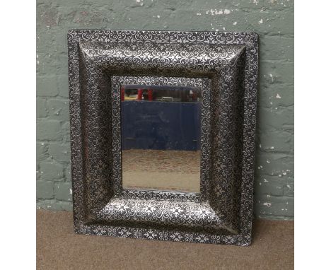 A bevel edge wall mirror in painted silver gilded cushion frame.