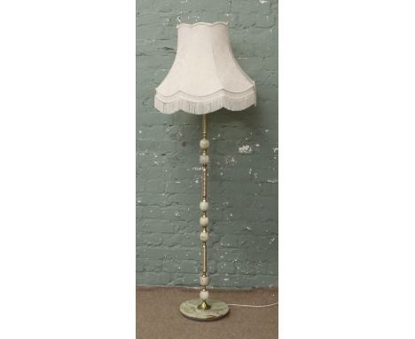 An ornate brass and onyx standard lamp with large cream shade.