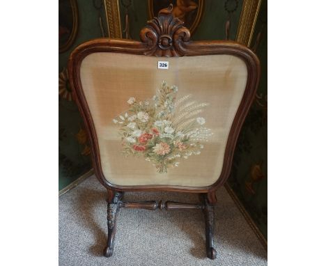 A Rosewood Firescreen, circa early 19th century, Having a woven floral panel on silk, raised on scroll supports, 105cm high, 