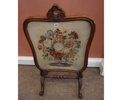 A Rosewood Firescreen, circa early 19th century, Decorated with a needlepoint floral panel, raised on scroll supports, 104cm 