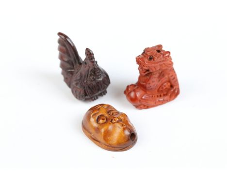 Three miniature wood netsuke figures to include dragon, hen and peculiar face