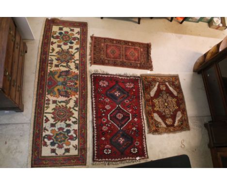 Group of four rugs, one red ground example with three diamond pattern to centre, measures 124cm x 75cm, burgundy, browns and 