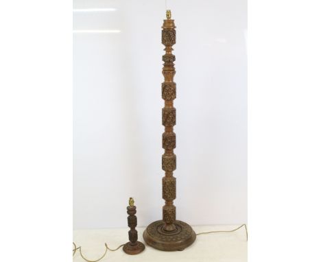 Intricately carved flora pattern segmented floor lamp with wide circular base, approx. H 152cm, together with a smaller sized