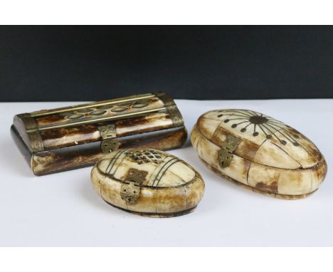 A collection of three North African carved bone trinket boxes with brass decoration. 