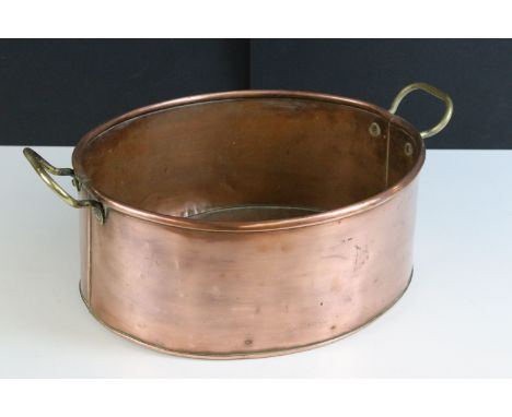 Copper oval planter with twin brass loop handles, 39cm long