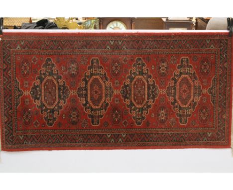 Persian Islamic floor rug having a red ground with four blue medallions with a geometric border.&nbsp;Measures 150 x 69cm.