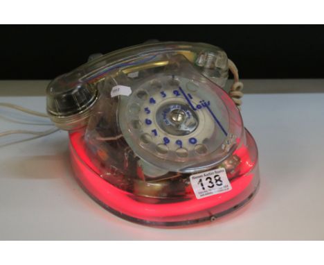 A vintage / Retro analogue telephone with clear encasement and neon light. 