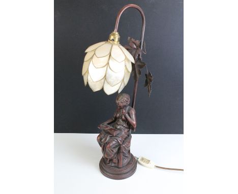 Art Nouveau bronze effect table lamp featuring a seated lady reading a book with leaf detail to top and lotus style lamp shad