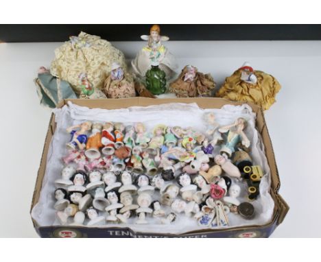 A large collection of antique ceramic pin cushion dolls and doll heads of various sizes and styles. 