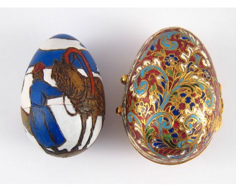 A Russian brass Easter egg with champleve enamel floral decoration, ht.8cm., and a treen Easter egg incised and painted with 