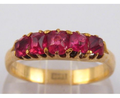 An 18 carat gold five stone red spinel ring, approx 4.8mm wide, ring size R, 4.4 gms.