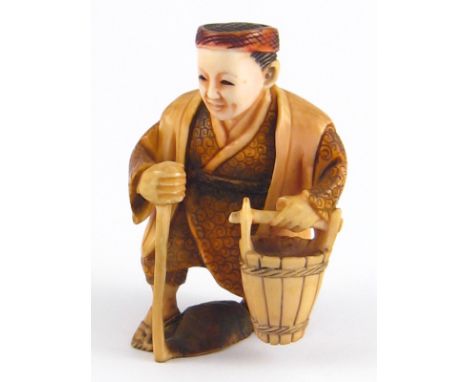 A 1920s netsuke of a gentleman carrying a bucket.