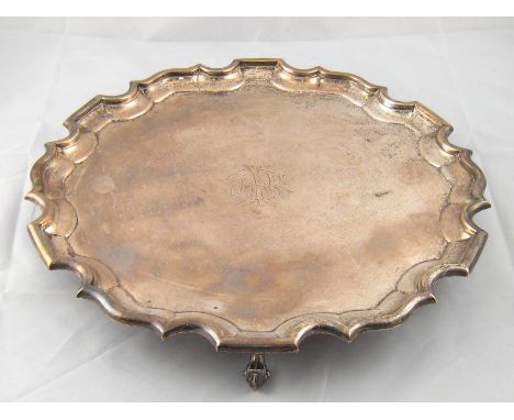 A silver waiter with chippendale rim on three leaf capped feet by Johnson Walker and Tolhurst, London, 1909.36cm. across, wt.
