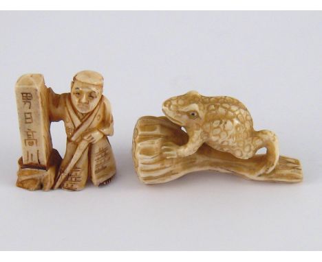 Two ivory netsuke, circa 1920, one a toad on a flower head, the other a man beside a post, with Chinese characters.