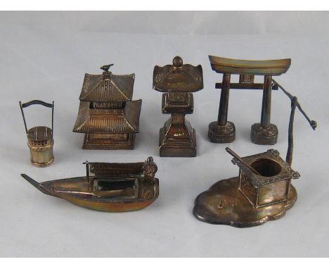A group of Chinese silver condiment pieces comprising an arch spice dispenser,, a two piece spice and mustard temple, a tall 