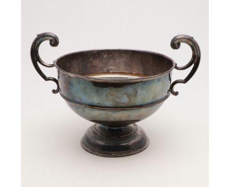 of circular form, with twin flying-scroll handles, raised on a domed foot and engraved on one side with the emblem of the Roy
