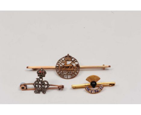 Two military brooches one surmounted a red enamel crown, a further for the Royal Berkshire Regiment, together with a further 