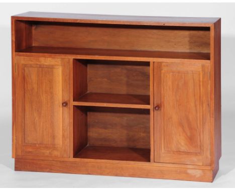 An Arts and Crafts walnut bookcase attributed to Heals, circa 1930, with a single open shelf above to short open shelves flan