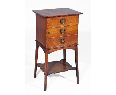 An Arts & Crafts oak smoker's cabinet with three dummy drawers with heart shaped metal handles, raised on square tapering leg