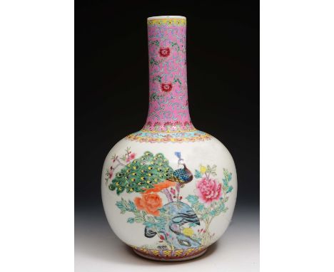 A Chinese porcelain bottle vase 20th Century painted with peacock, peonies and rock work with ruyi border, drilled for a lamp