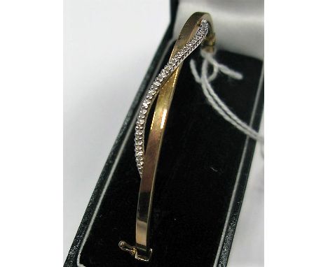 A Modern Bangle, with claw set highlights, hinged to snap clasp, stamped "375".
