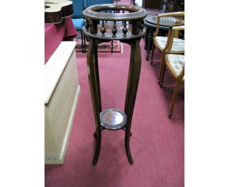 An Early XIX Century Walnut Jardiniere Stand, with spindle decoration to circular top, stepped under shelf united by sabre le