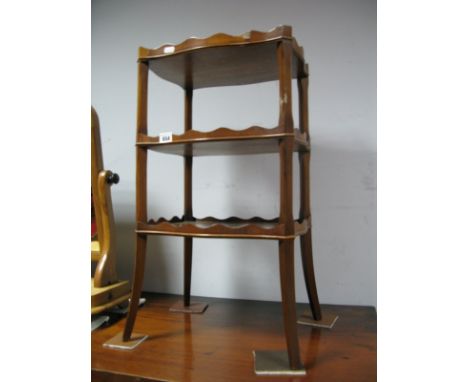 A Reprodux Yew Wood Three Tier Whatnot, with wavy gallery to each shelf, on splayed legs.