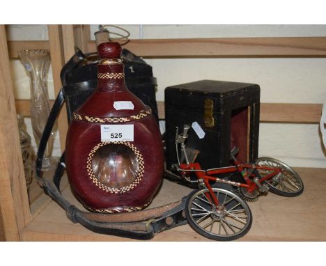 A leather cased carriage clock holder together with a leather clad bottle, wine flask and model bicycle