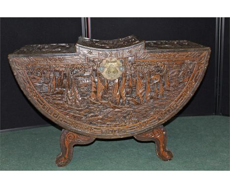 Early 20th Century Oriental carved trunk, the arched top carved with boating scenes, conforming carving to the body
