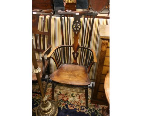 Early 19th Century elm and fruitwood Windsor chair, the high wheel and stick back above a carved panel seat on turned support