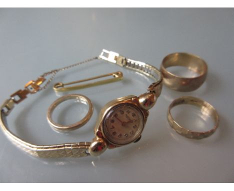 Three 9ct gold wedding bands, a tie pin and a 9ct gold cased Rotary wristwatch with a gold plated strap