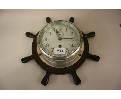 Early 20th Century circular aluminium ships clock mounted on an oak bracket in the form of a ships wheel