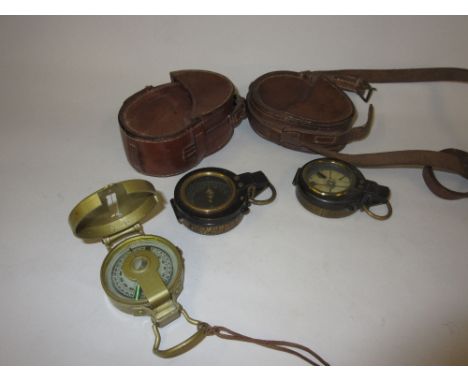Two early 20th Century leather cased compasses, together with a later compass
