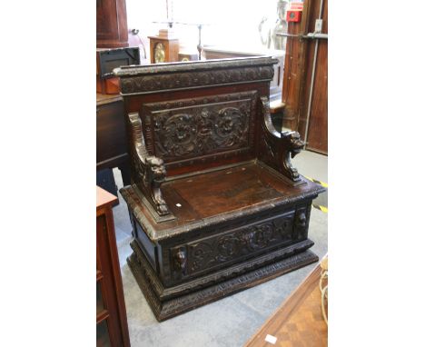 19th Century oak hall bench in Renaissance style, the carved back and animal head arms above a box seat decorated in carved r