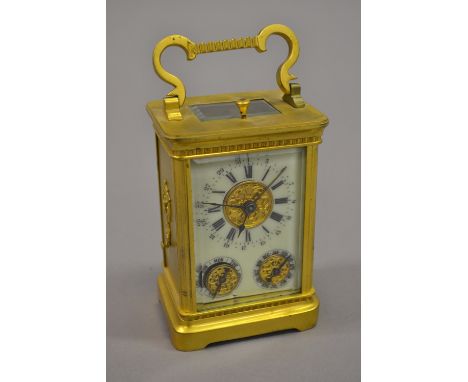 Early 20th Century French gilt brass carriage clock, the ceramic dial with Arabic and Roman numerals, with subsidiary day and