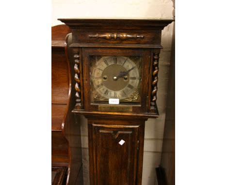 1930's Oak grandmother clock with a square hood flanked by barley twist columns above a panelled door, the gilt brass and sil