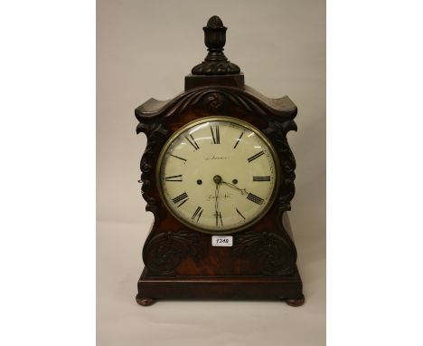 Late Regency or early Victorian mahogany bracket clock, the shaped case with applied carved floral decoration and finial surm