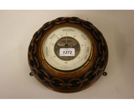 19th Century circular aneroid barometer mounted in a carved oak chain link frame