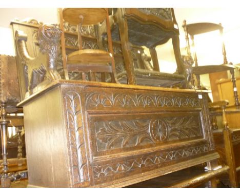 19th Century carved oak hall bench, the panelled back above a box base with lion mask arms
