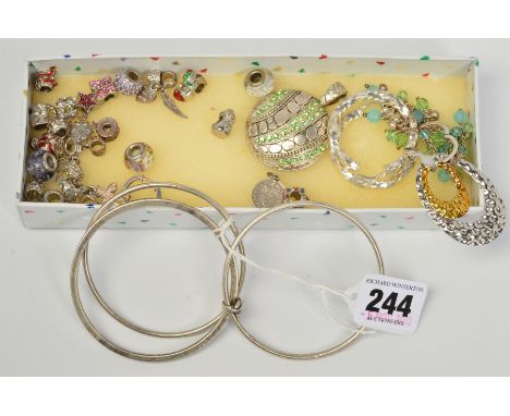 A SELECTION OF SILVER AND WHITE METAL JEWELLERY, to include charms, a triple bangle, pendants, two pairs of hoop earrings and
