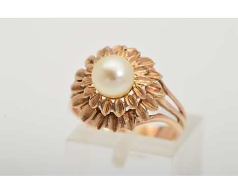 A PEARL RING, designed with a central cultured pearl within a tiered floral surround to the trifurcated shoulders, ring size 
