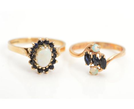 TWO 9CT GOLD OPAL AND SAPPHIRE RINGS, the first designed with a central oval opal cabochon within a circular sapphire surroun