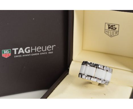 A CASED FORMULA 1 TAG HEUR RING, the stainless steel ring with a central line of white ceramic panels and a brilliant cut dia