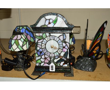 A TIFFANY STYLE TABLE CLOCK, height 26cm, together with four similar smaller table lamps, one shaped as a butterly, height 23