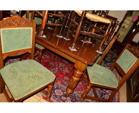 AN EDWARDIAN OAK WIND OUT DINING TABLE, canted corners, on turned and fluted legs and brown ceramic casters, two additional l