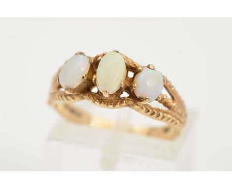 A 9CT GOLD OPAL RING, designed with three oval opal cabochons, each with four claw settings and textured surround, with a 9ct