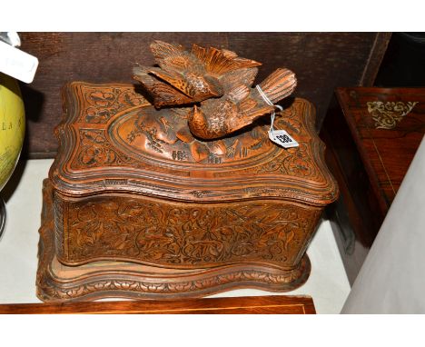 A BLACK FOREST TEA CADDY, in need of restoration, having carved fighting birds to the cover, width 30cm x depth 18cm x height
